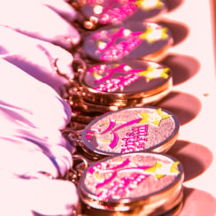 Girls on the Run medals are stacked neatly on a table